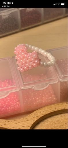 several plastic containers filled with pink and white beads