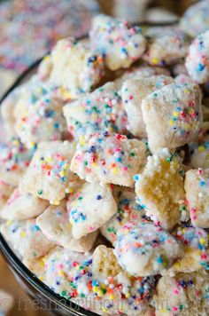 a glass bowl filled with sprinkles and sugary cookies on top of a table