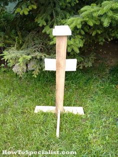 a wooden pole in the grass near some trees