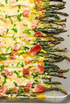 asparagus spears with ham and cheese on a baking sheet, ready to be cooked