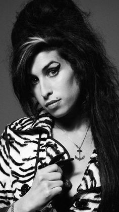 a black and white photo of a woman with long hair wearing a zebra print shirt