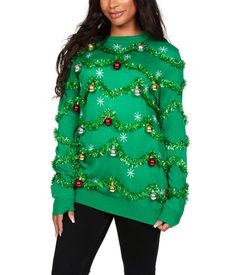 a woman wearing a green sweater with christmas decorations on the top and bottom, standing in front of a white background