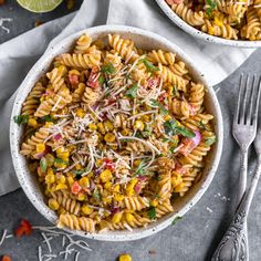 two bowls filled with pasta and garnished with parmesan sprinkles