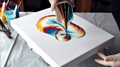 someone is painting an abstract design on a box