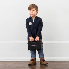 a young boy holding a briefcase in his hands