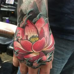 a person's hand with a tattoo on it and a flower in the middle