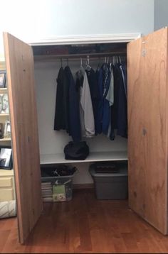 an open closet with clothes hanging on the wall