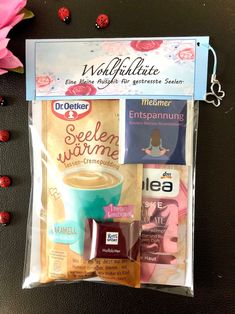 an assortment of coffee products in a clear bag on a black surface with pink flowers