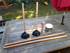 three wooden mallets sitting on top of a picnic table next to paint and wood utensils