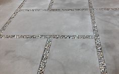 a cement walkway with stones and gravel in the middle