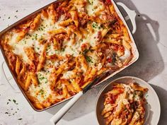 a casserole dish filled with pasta and sauce next to a bowl of parmesan cheese