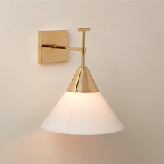 a wall light with a white glass shade on the side and a gold metal arm