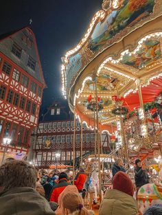 many people are gathered around the merry go round