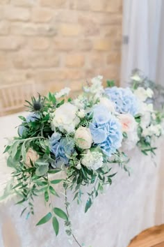 blue and white flowers are arranged on the table for an elegant centerpiece at this wedding reception