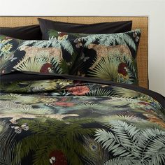 a bed covered in black and green tropical print