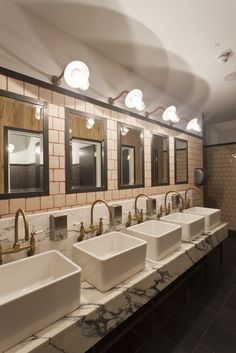 a bathroom with marble counter tops and double sinks in front of two mirrors on the wall