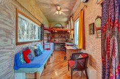 the inside of a house with wood flooring and colorful curtains on the windowsill