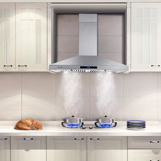 a kitchen with white cabinets and stainless steel appliances, including a hood over the stove