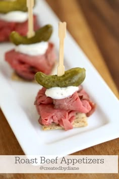 small appetizers with pickles, cheese and meat are on a white plate