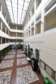 the inside of a large building with lots of windows and stone flooring in it