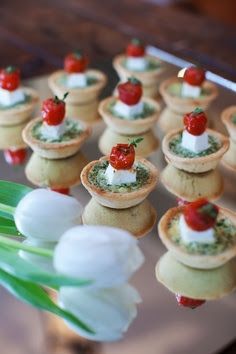 small appetizers are arranged on a tray with tulips