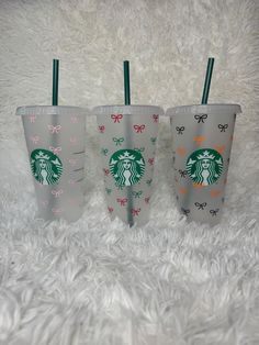 three starbucks cups with bows on them are sitting on a white furnishing area