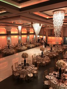 an elegant ballroom with chandeliers and tables