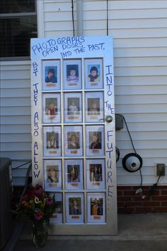 a white door with pictures on it in front of a brick wall and flowers outside