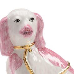 a pink and white dog figurine with a gold collar around it's neck