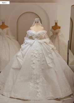 a white wedding dress on display in front of mannequins wearing gowns