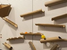 there are several pieces of cardboard taped to the wall with pegs and balls on them