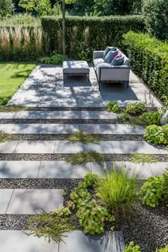 an outdoor seating area in the middle of a garden with stone steps leading up to it