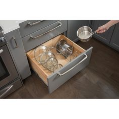 an open drawer with pots and pans in it