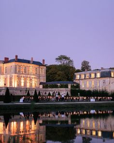 a large building with lots of windows next to a body of water in front of it