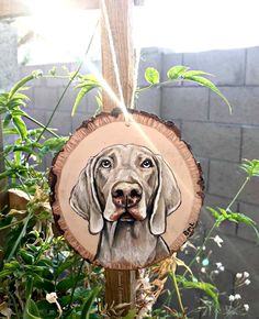 a wooden ornament with a dog's face on it hanging from a tree