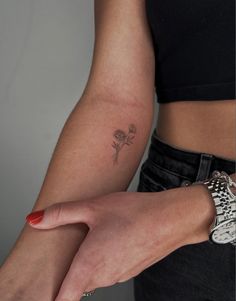 a woman's arm with a flower tattoo on it