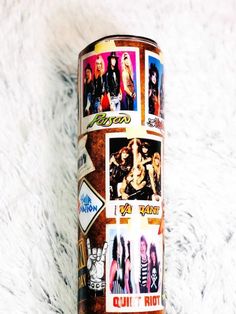 a can with pictures on it sitting on top of a white carpet next to a wall