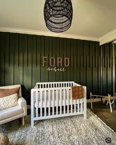 a white crib in a room with green walls and wood paneling on the wall