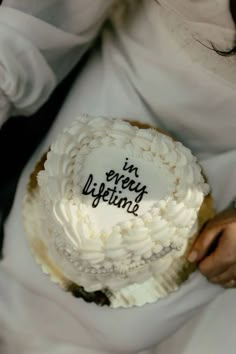 a person holding a cake with the words in every lifetime written on it,