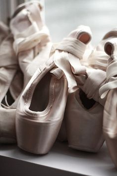 several pairs of ballet shoes with bows on them