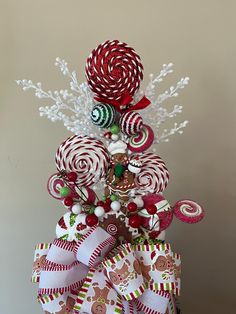 a christmas tree made out of candy canes and other holiday decorations on top of a table