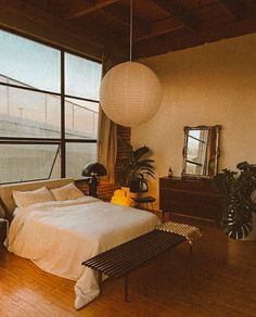 a bedroom with large windows and a bed in the middle, next to a wooden floor