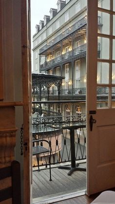 an open door leading to a building with balcony and balconies on the second floor