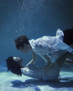 a man and woman are underwater in the water