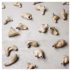 several pieces of clay sitting on top of a cement floor next to each other with eyes and nose shapes