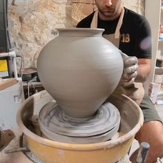 a man is making a vase out of clay