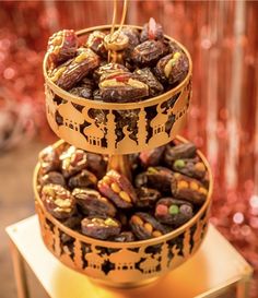 two tiered trays filled with nuts on top of a table