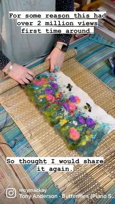 a woman is working on an art project with flowers in the middle and words above it