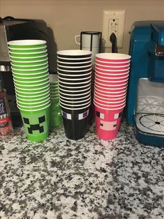 there are many different colored cups on the counter