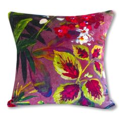 a purple pillow with red and yellow flowers on the front, along with green leaves